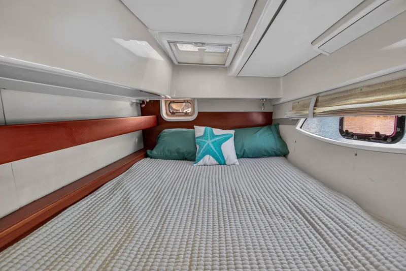 Papillon Yacht Photos Pics Cozy cabin interior of 2012 Leopard 39 yacht with bed and starfish pillow.