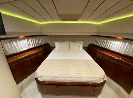  Yacht Photos Pics Luxurious bedroom interior of 2002 Ferretti Yachts 72, featuring elegant wood finishes and ambient lighting.