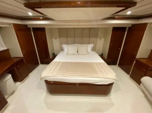  Yacht Photos Pics Luxurious bedroom interior of a 2002 Ferretti Yachts 72, featuring elegant wood finishes.