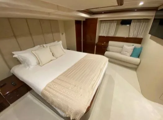  Yacht Photos Pics Luxurious bedroom interior of 2002 Ferretti Yachts 72, featuring elegant bedding and cozy seating.