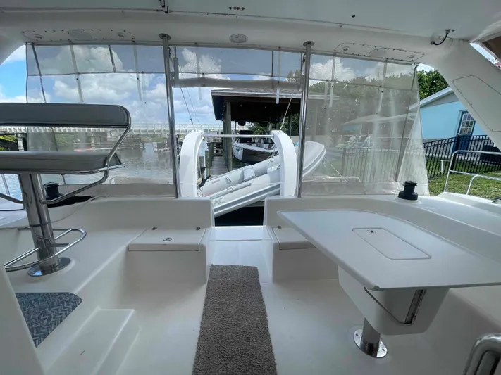 Endless Summer Yacht Photos Pics Interior view of 2008 Admiral Executive boat with seating and table, docked by the water.