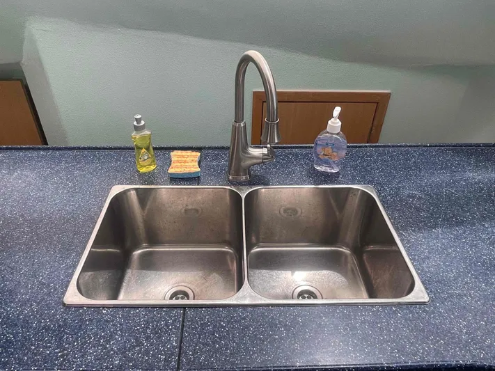 Endless Summer Yacht Photos Pics Double stainless steel sink with soap dispensers and sponge on blue countertop.
