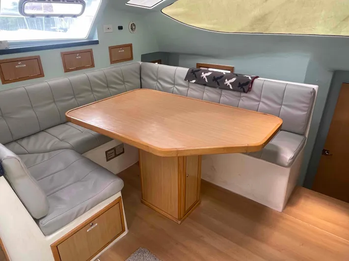 Endless Summer Yacht Photos Pics Luxurious 2008 Admiral Executive yacht interior with cushioned seating and wooden table.