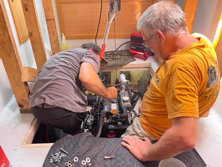 Endless Summer Yacht Photos Pics Two men repairing a 2008 Admiral Executive engine in a workshop.