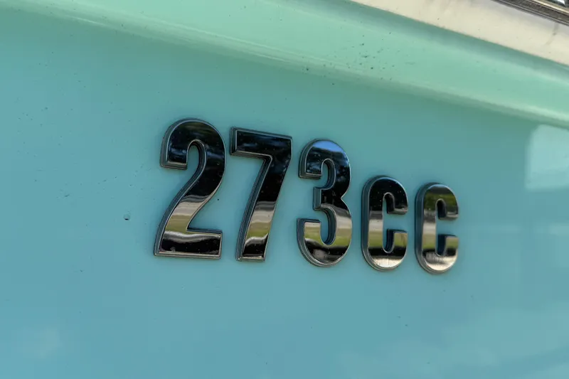 Stunning Seafoam Green Yacht Photos Pics Close-up of 2022 Everglades 273 Center Console boat emblem on light blue surface.