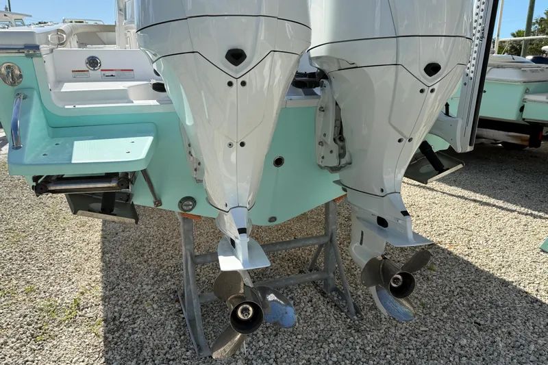 Stunning Seafoam Green Yacht Photos Pics Twin outboard motors on a 2022 Everglades 273 Center Console boat, displayed on gravel.