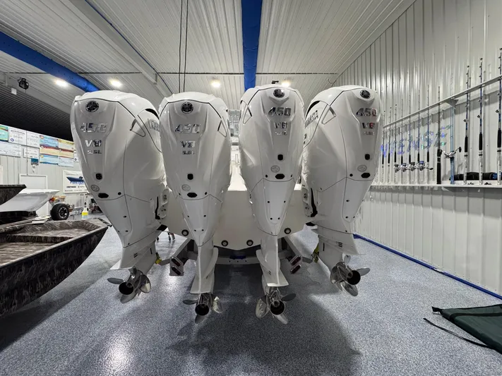  Yacht Photos Pics 2024 Contender 44 ST boat with four powerful 450 V8 outboard engines in a showroom.