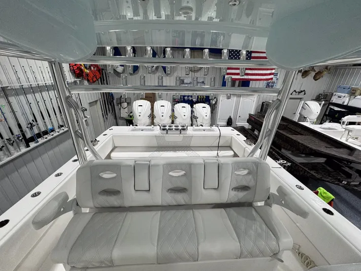  Yacht Photos Pics 2024 Contender 44 ST boat interior with seating, fishing rods, and American flag in background.