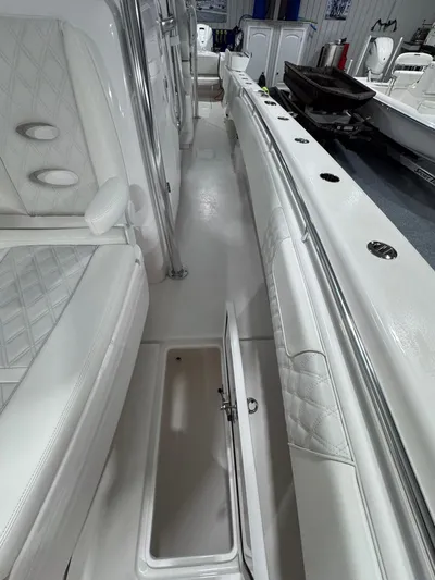  Yacht Photos Pics 2024 Contender 44 ST boat interior with white seating and open storage compartment.