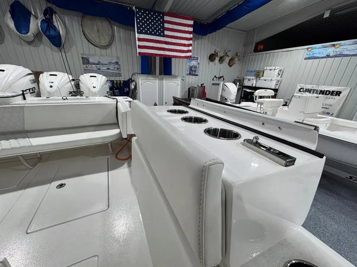  Yacht Photos Pics 2024 Contender 44 ST boat interior with seating, rod holders, and American flag in showroom.