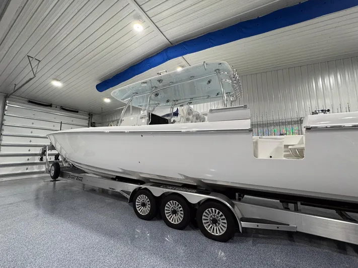  Yacht Photos Pics 2024 Contender 44 ST boat on trailer in a spacious indoor garage.