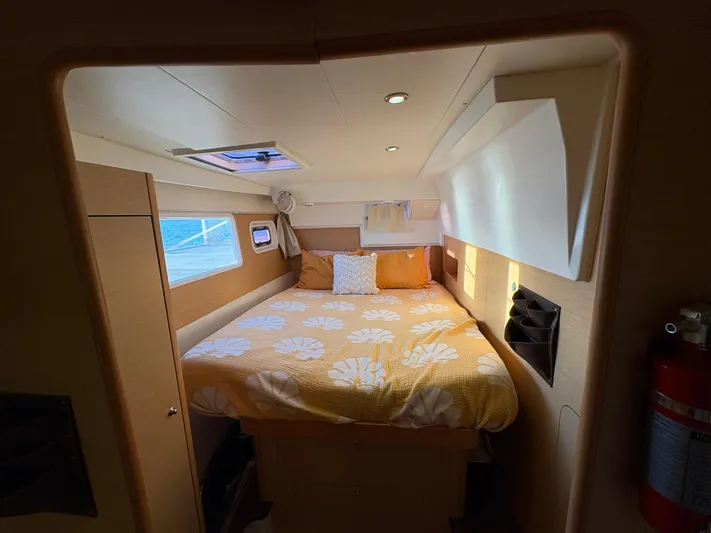Chasing Summer Yacht Photos Pics Cozy cabin interior of 2012 Lagoon 400 catamaran with a comfortable bed and natural lighting.