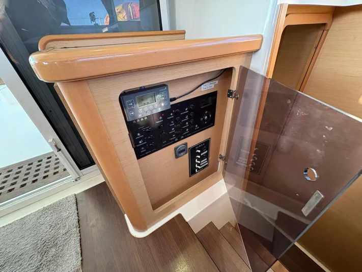Chasing Summer Yacht Photos Pics Control panel inside 2012 Lagoon 400 yacht, featuring wooden finish and modern electronics.