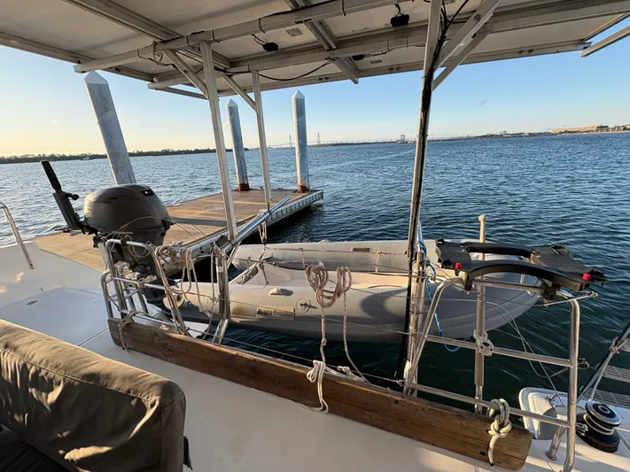 Chasing Summer Yacht Photos Pics Lagoon 400 catamaran docked, featuring a small dinghy and serene waterfront view.
