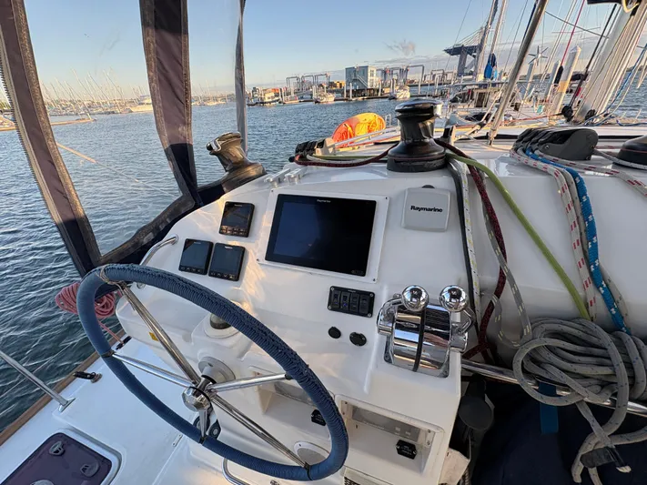 Chasing Summer Yacht Photos Pics Helm of 2012 Lagoon 400 catamaran with navigation equipment, docked in marina.