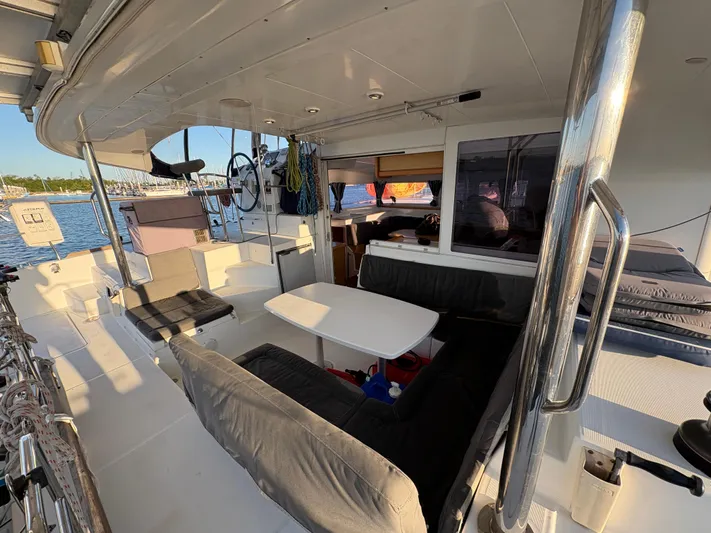Chasing Summer Yacht Photos Pics 2012 Lagoon 400 catamaran interior with seating, table, and helm, docked by the water.