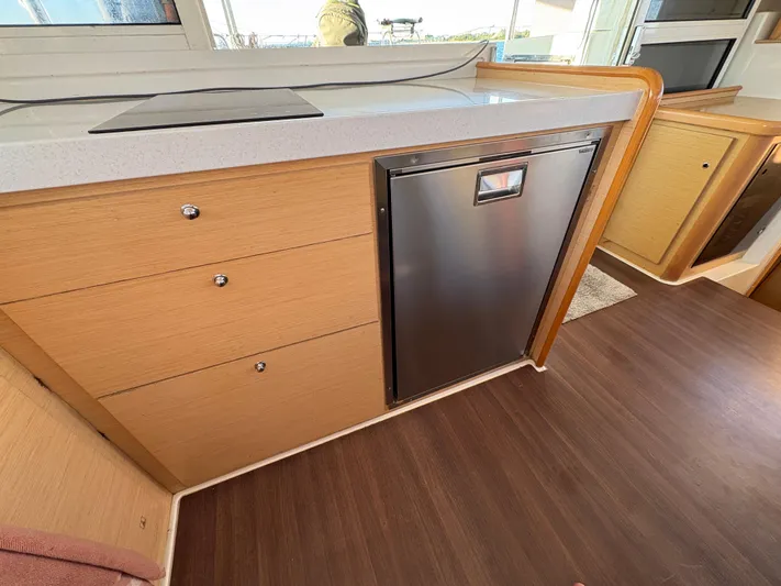 Chasing Summer Yacht Photos Pics Interior of 2012 Lagoon 400 yacht with modern kitchen cabinetry and stainless steel fridge.