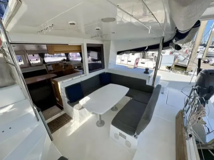 Chasing Summer Yacht Photos Pics 2012 Lagoon 400 catamaran interior with seating area and table, docked at marina.