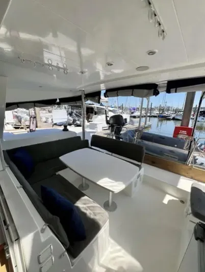 Chasing Summer Yacht Photos Pics Spacious 2012 Lagoon 400 catamaran cockpit with seating, table, and marina view.