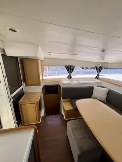 Chasing Summer Yacht Photos Pics Interior of 2012 Lagoon 400 catamaran with dining area, wooden cabinetry, and large windows.