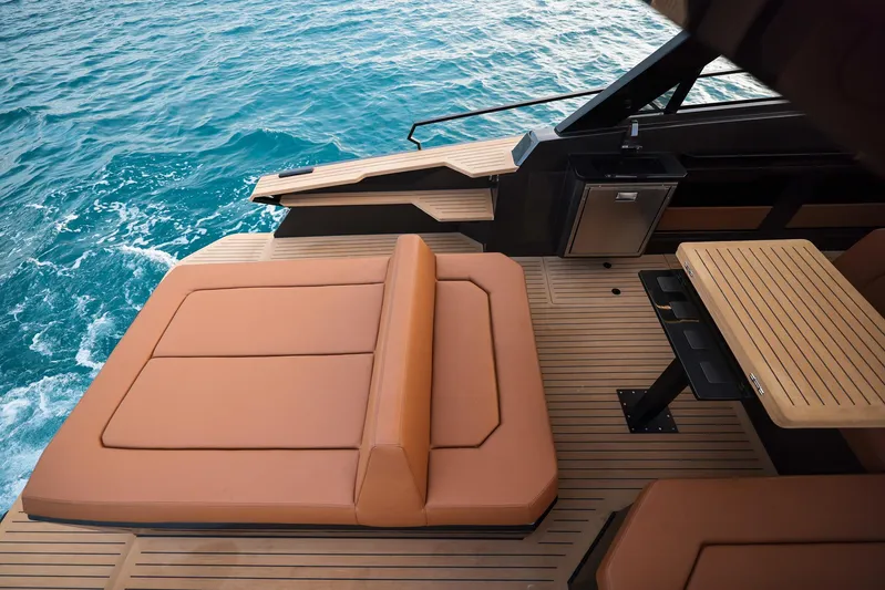  Yacht Photos Pics Luxurious Focus 3X 2025 yacht deck with tan seating and wooden table on blue ocean.