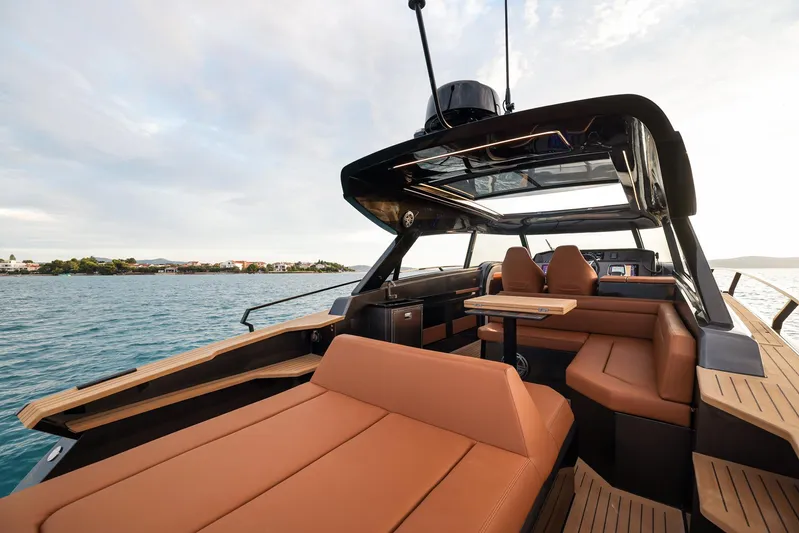  Yacht Photos Pics Luxurious 2025 Focus 3X yacht interior with tan seating and sleek design on open water.