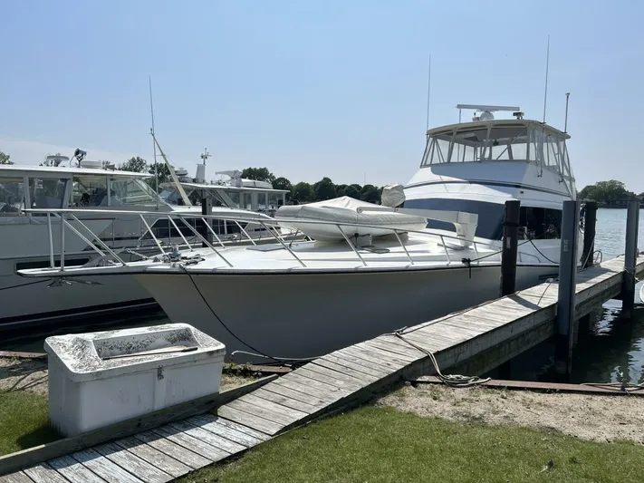 Seclusion Yacht Photos Pics 1988 Ocean Yachts 55 Super Sport docked at a marina on a sunny day.