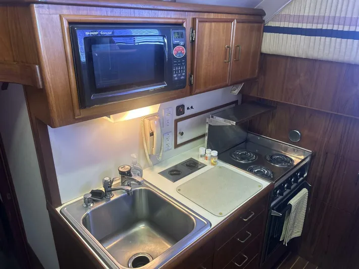 Seclusion Yacht Photos Pics 1988 Ocean Yachts 55 Super Sport kitchen with microwave, stove, and sink.