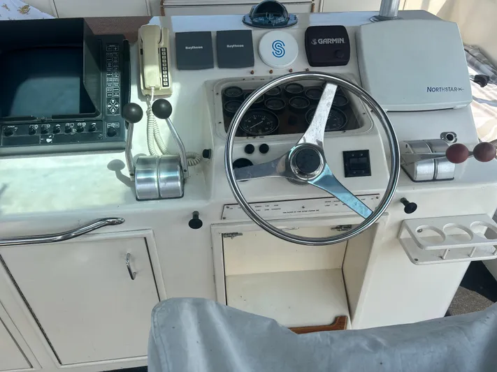 Seclusion Yacht Photos Pics Cockpit of 1988 Ocean Yachts 55 Super Sport with steering wheel and navigation equipment.