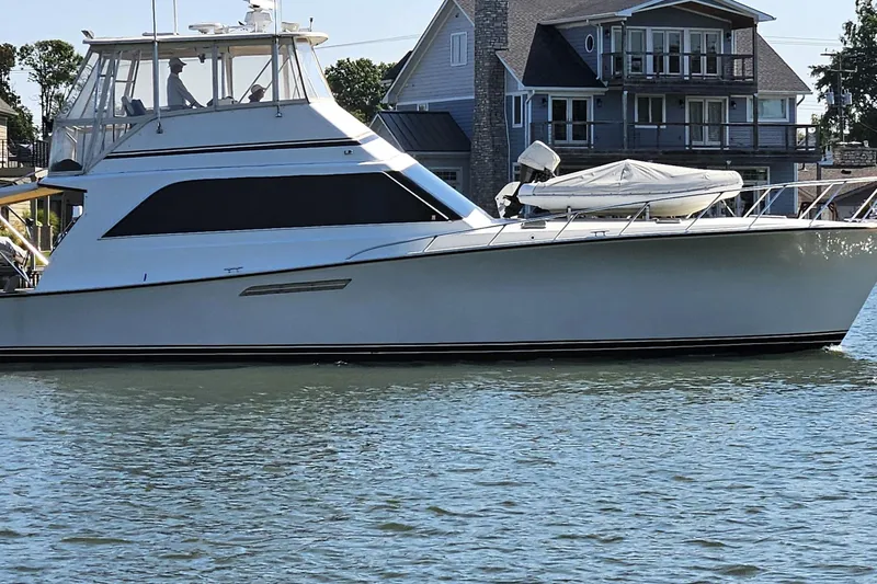 Seclusion Yacht Photos Pics 1988 Ocean Yachts 55 Super Sport on calm water near waterfront homes.