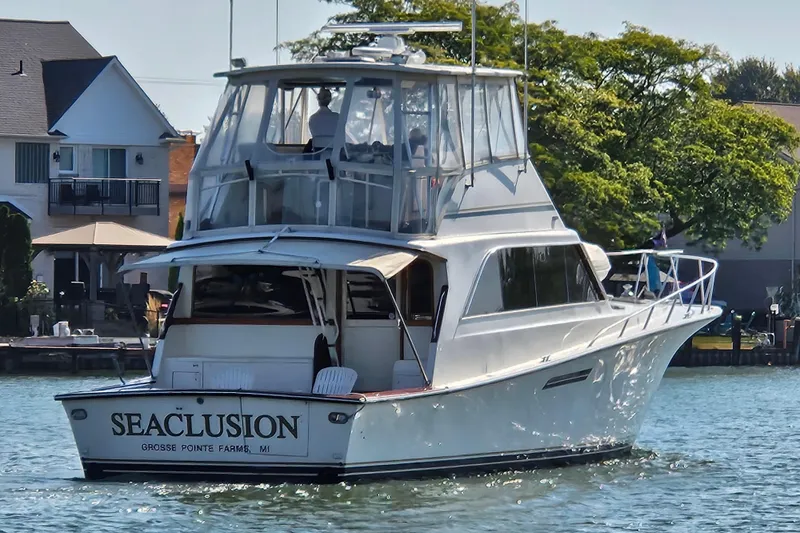 Seclusion Yacht Photos Pics 1988 Ocean Yachts 55 Super Sport cruising near waterfront homes.
