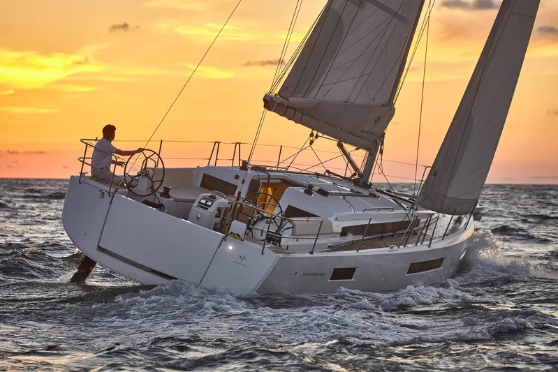  Yacht Photos Pics 2024 Jeanneau Sun Odyssey 440 sailing at sunset on open sea.