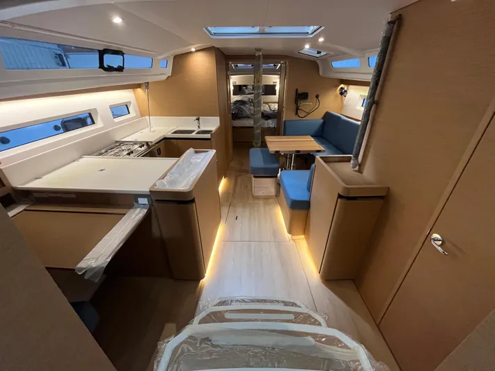  Yacht Photos Pics Interior of 2024 Jeanneau Sun Odyssey 440 yacht, featuring modern kitchen and seating area.