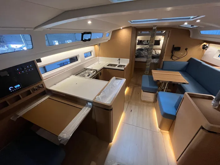  Yacht Photos Pics 2024 Jeanneau Sun Odyssey 440 interior with modern kitchen and cozy seating area.