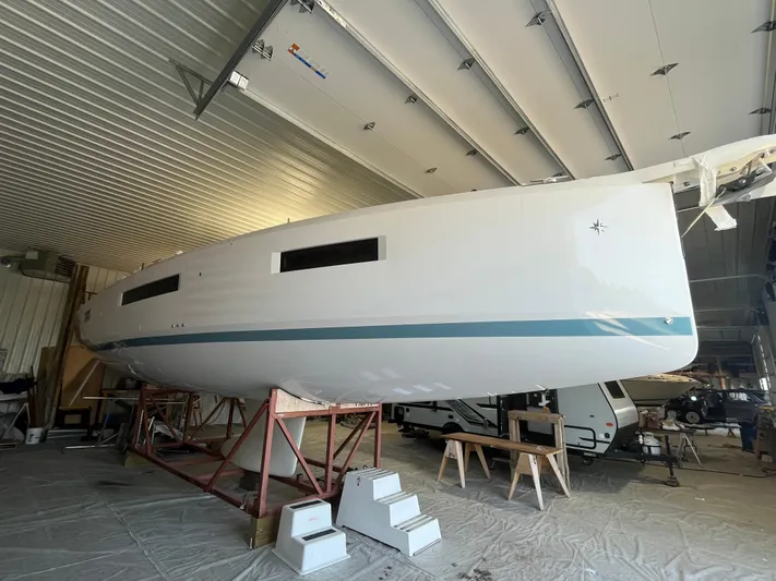  Yacht Photos Pics 2024 Jeanneau Sun Odyssey 440 sailboat in indoor storage, showcasing sleek hull design.