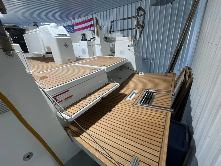  Yacht Photos Pics 2024 Jeanneau Sun Odyssey 440 yacht with teak deck in a storage facility.