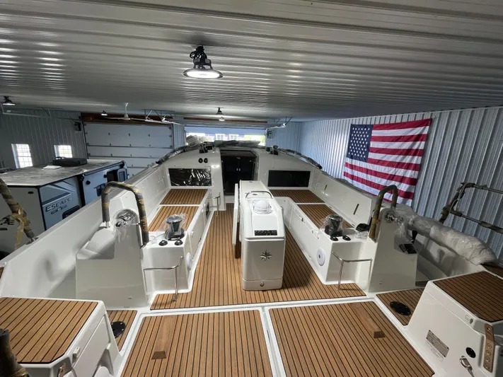  Yacht Photos Pics 2024 Jeanneau Sun Odyssey 440 yacht in storage, featuring teak deck and American flag.