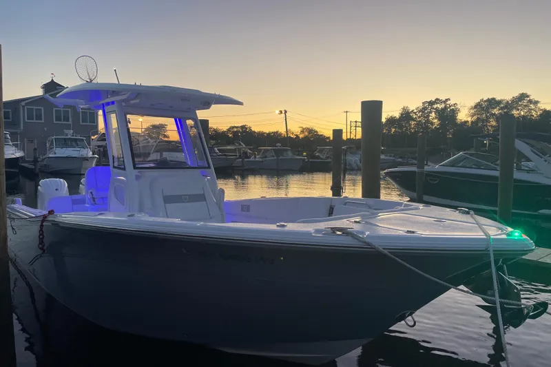  Yacht Photos Pics 2026 Sea Fox 268 Commander boat docked at sunset, illuminated with blue lights.