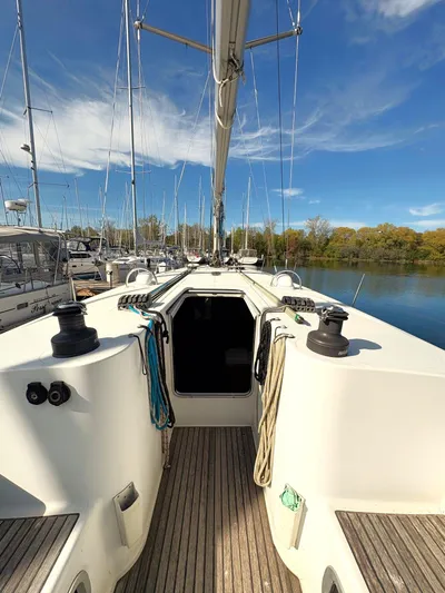 Brown Sugar Yacht Photos Pics 2005 Beneteau First 47.7 sailboat deck with ropes and winches, docked under a clear sky.