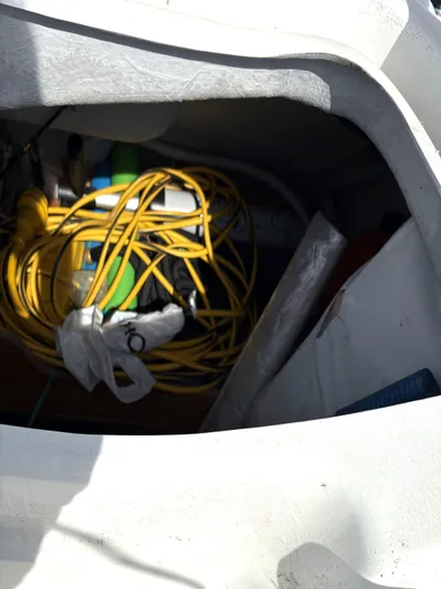 Brown Sugar Yacht Photos Pics Storage compartment on a 2005 Beneteau First 47.7 sailboat with coiled yellow rope.