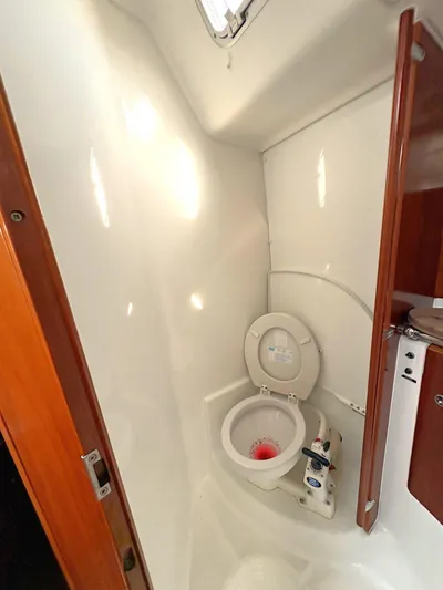 Brown Sugar Yacht Photos Pics 2005 Beneteau First 47.7 yacht bathroom with toilet and wooden accents.