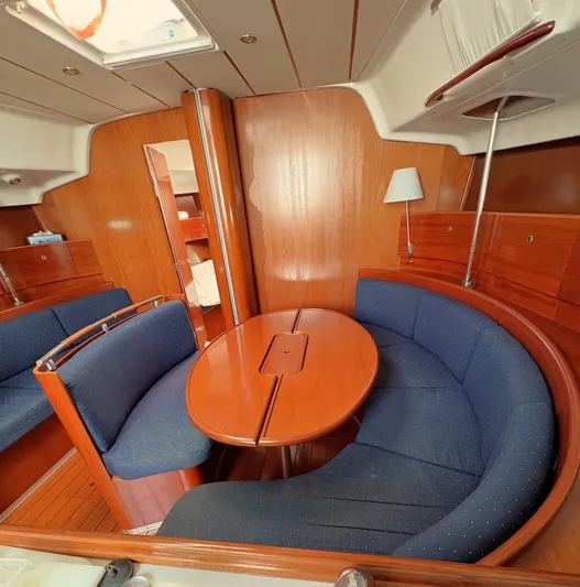 Brown Sugar Yacht Photos Pics Interior of 2005 Beneteau First 47.7 yacht with wooden finish and blue seating.