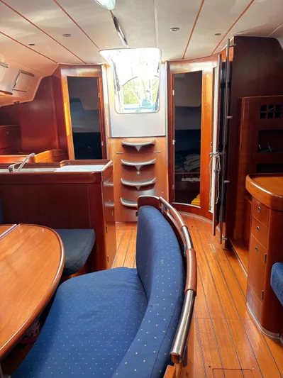 Brown Sugar Yacht Photos Pics Interior of 2005 Beneteau First 47.7 yacht with wooden furnishings and blue seating.