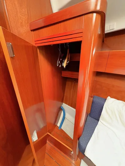 Brown Sugar Yacht Photos Pics Wooden interior of 2005 Beneteau First 47.7 yacht cabin with open closet.
