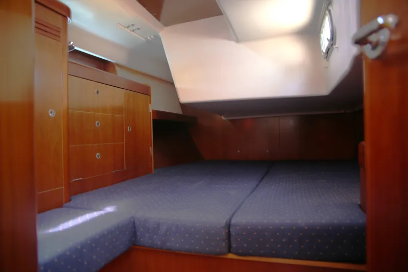 Brown Sugar Yacht Photos Pics Cozy cabin interior of 2005 Beneteau First 47.7 yacht with wooden finish and blue bedding.