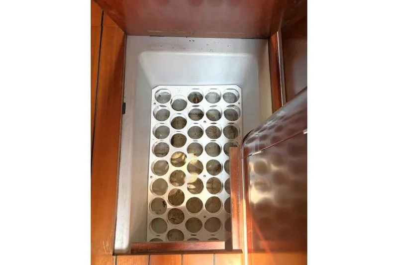 Brown Sugar Yacht Photos Pics Storage compartment on 2005 Beneteau First 47.7 sailboat, featuring wooden finish and circular slots.