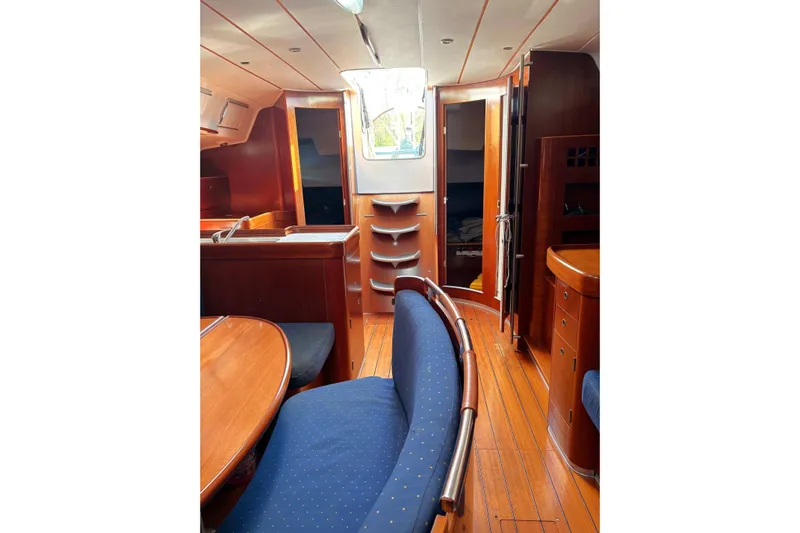 Brown Sugar Yacht Photos Pics Interior of 2005 Beneteau First 47.7 yacht with wooden furnishings and blue seating.