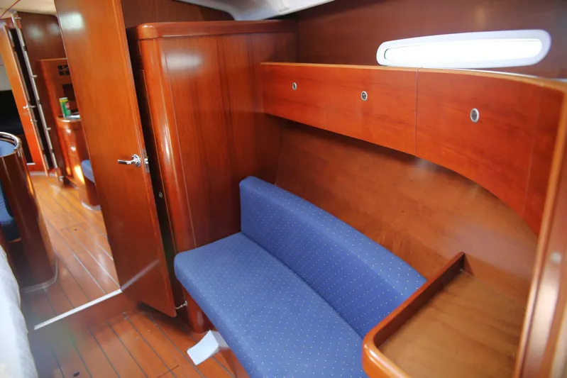 Brown Sugar Yacht Photos Pics Interior of 2005 Beneteau First 47.7 yacht with wooden finish and blue seating.