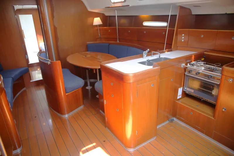 Brown Sugar Yacht Photos Pics Interior of 2005 Beneteau First 47.7 yacht, featuring wood finish, kitchen, and seating area.