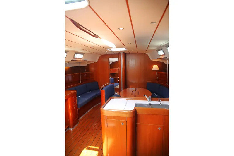 Brown Sugar Yacht Photos Pics Interior of 2005 Beneteau First 47.7 yacht with wooden finish and blue seating.